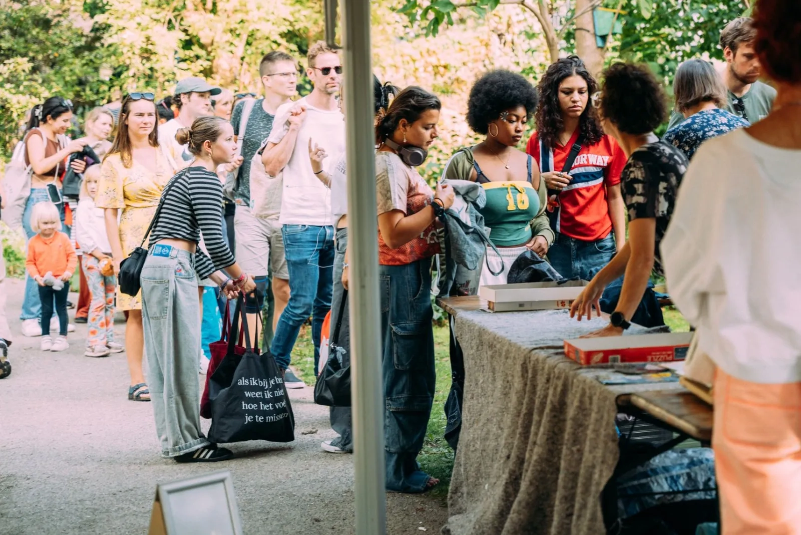 Bezoekers staan in de rij bij de kledingruil in de Tolhuistuin