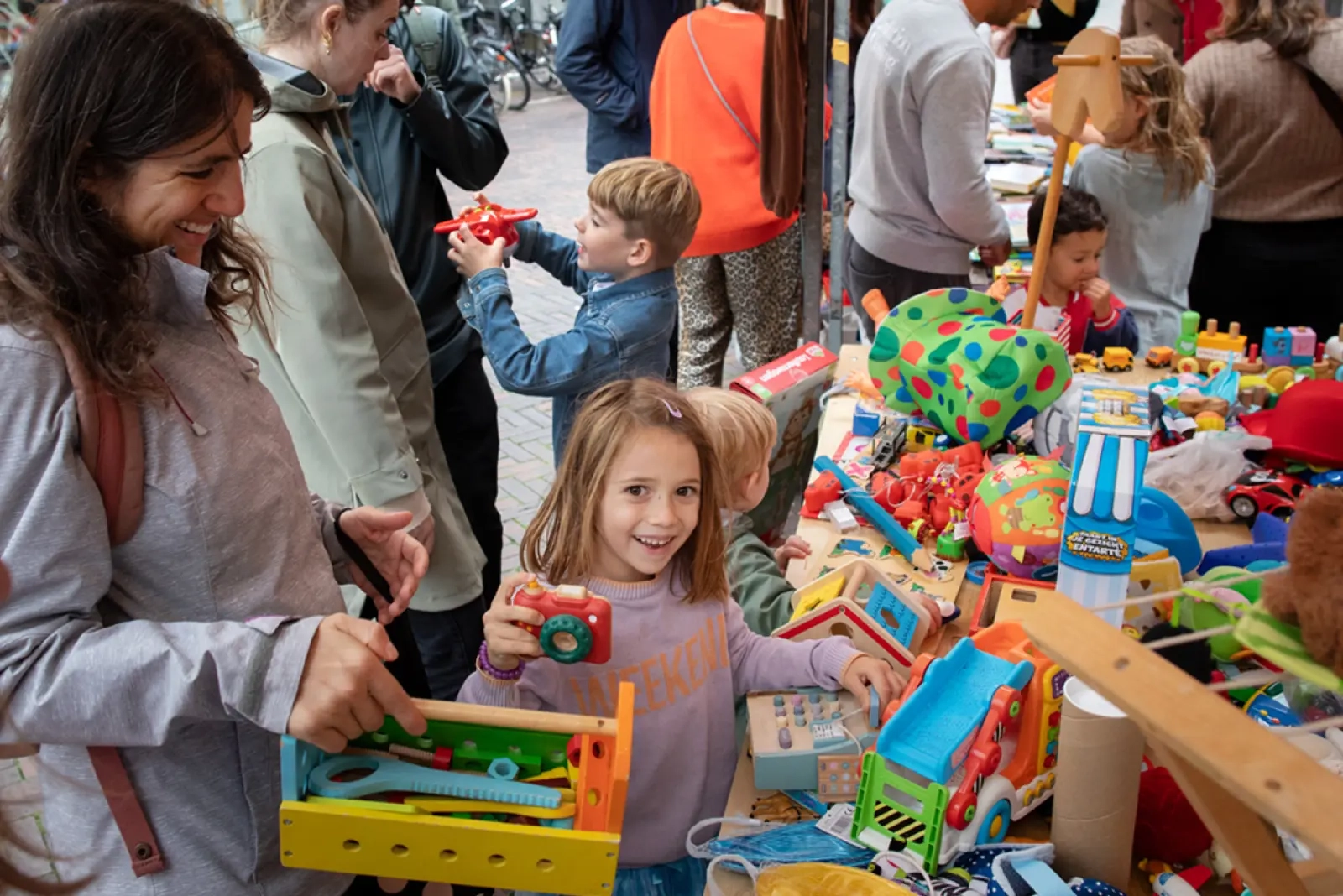 Kinderen kijken naar tweedehands speelgoed