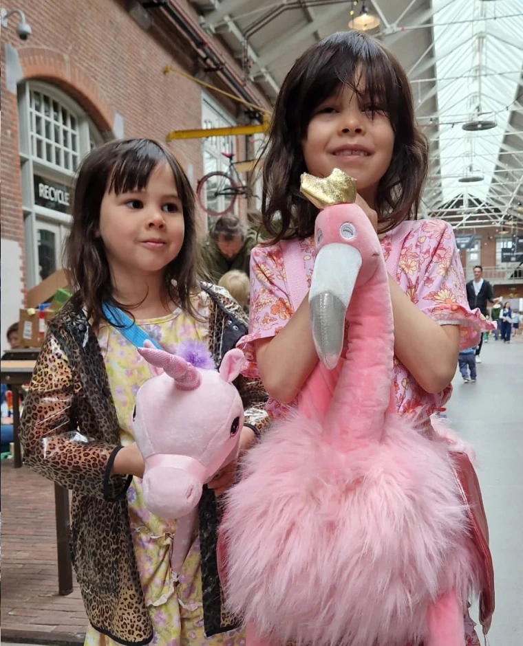 Meisjes met knuffel eenhoorn en flamingo op de NDSM