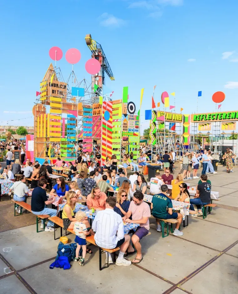 Gezinnen genieten van een kleurrijk buitenfestival met decoraties en activiteiten.