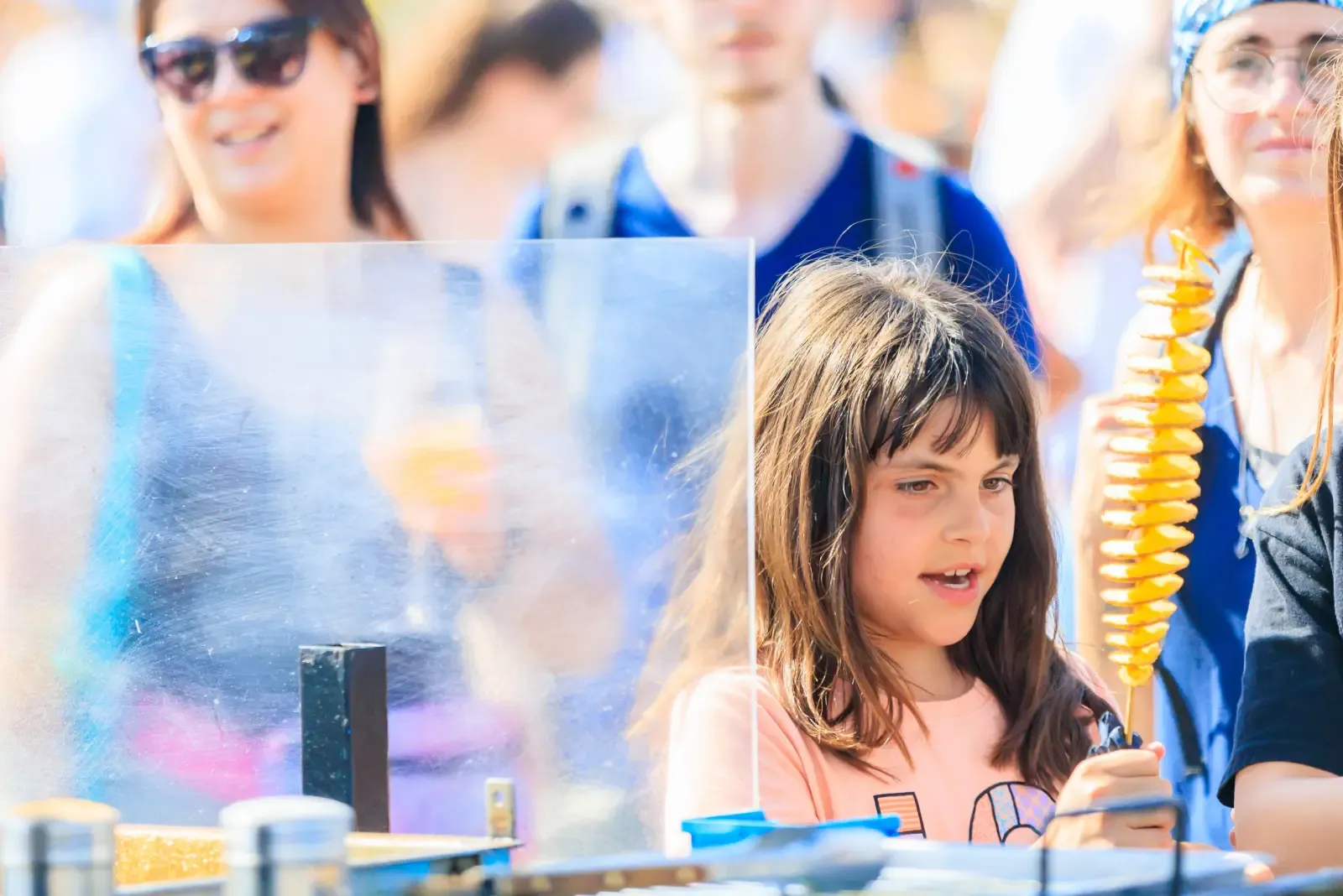 Een jong meisje eet chips terwijl ze op een festival zit.