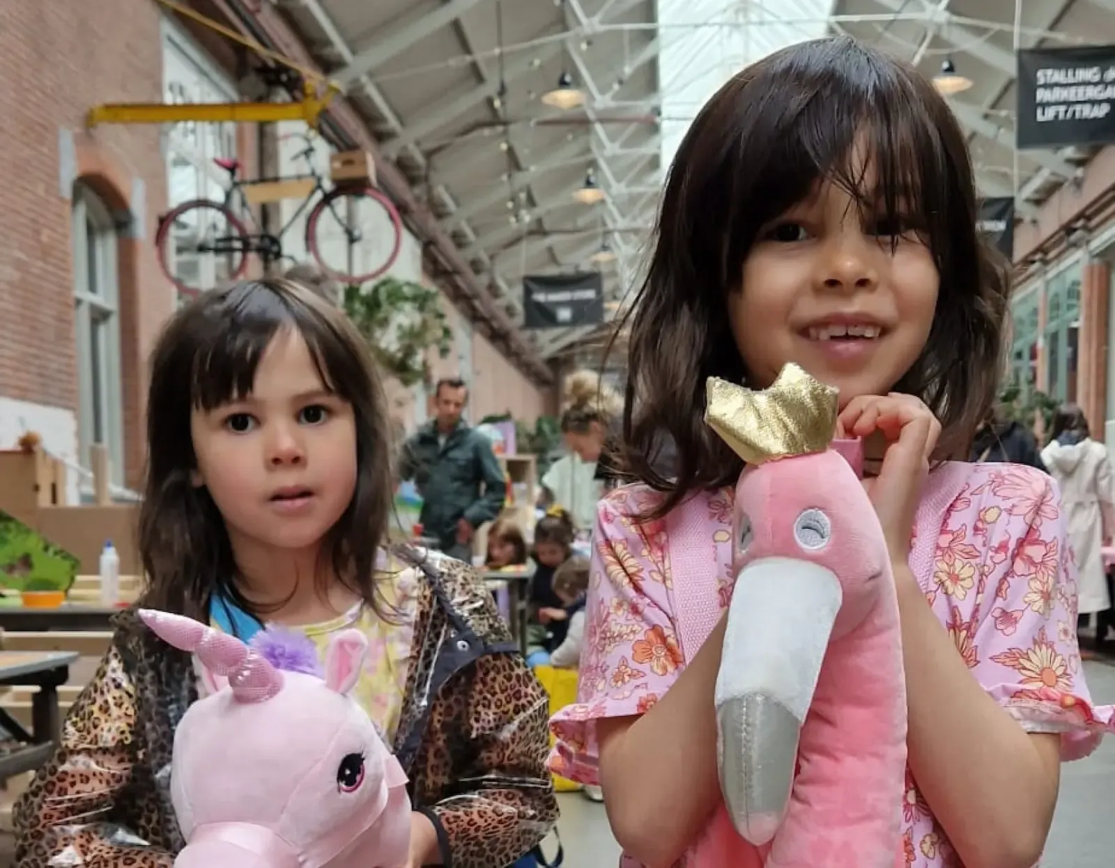 Meisjes spelen met eenhoorn- en flamingo-knuffels