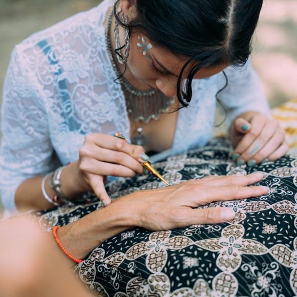 Jonge vrouw die henna-tatoegeringen maken